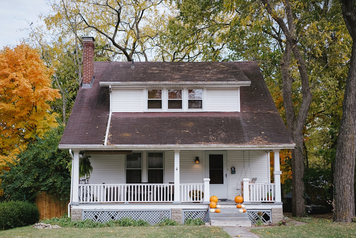 Cosy white two-storey home with a covered front porch and lawn (stock photo — replace with a real photo of this home).